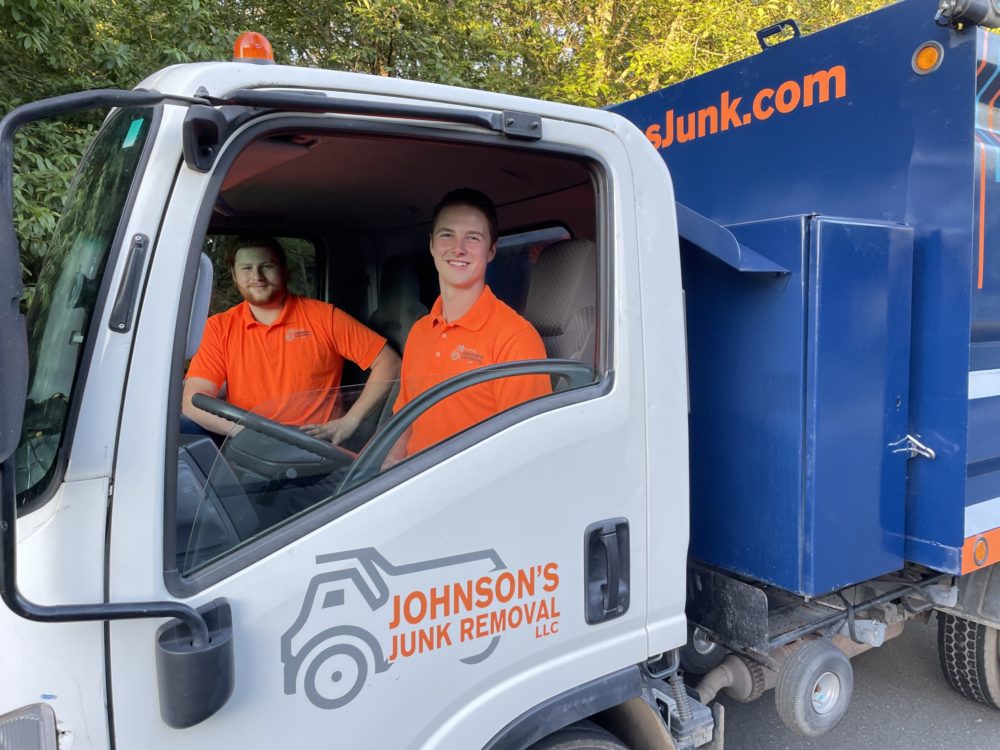 Johnson's Junk Removal professionals in a truck on their way to perform junk removal services