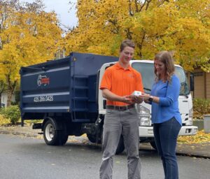 Junk removal professional quoting the cost of foreclosure cleanouts to a happy customer