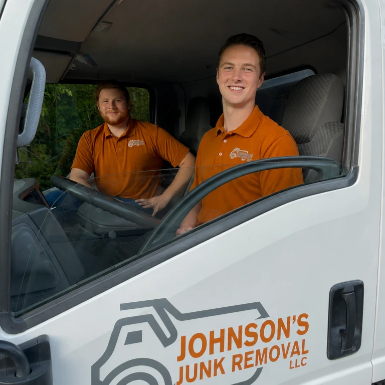 Junk removal professionals smiling in the truck