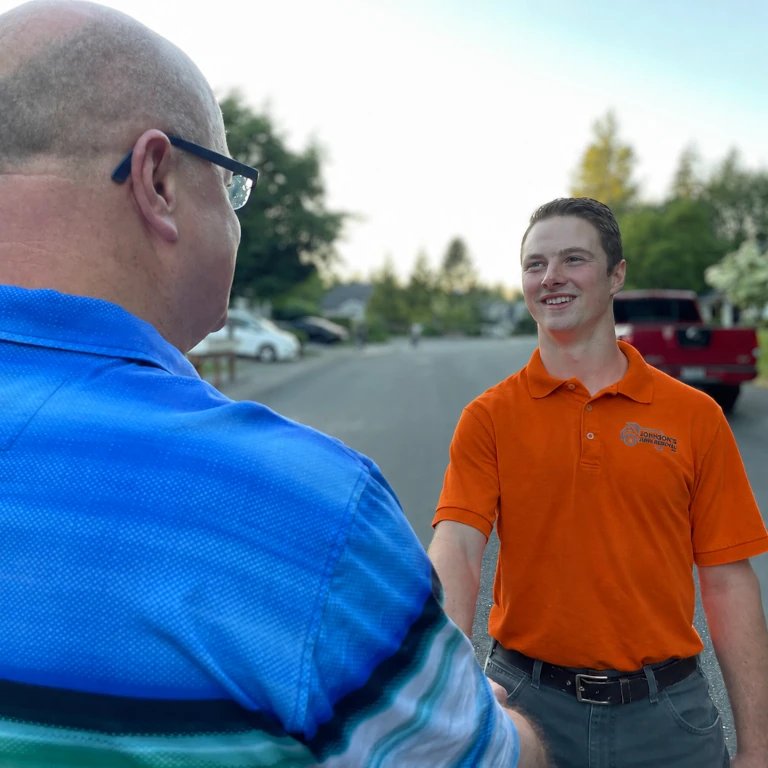 Johnson's Junk Removal crew shaking hands with a happy customer before providing hot tub removal services