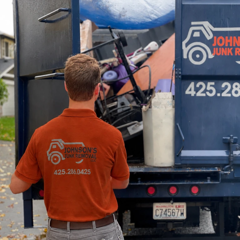 Johnson Junk Removal professional loading junk onto the truck during foreclosure cleanout services