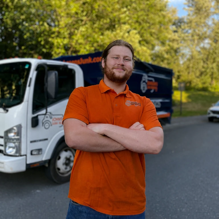 Johnson's Junk Removal professional smiling next to their truck