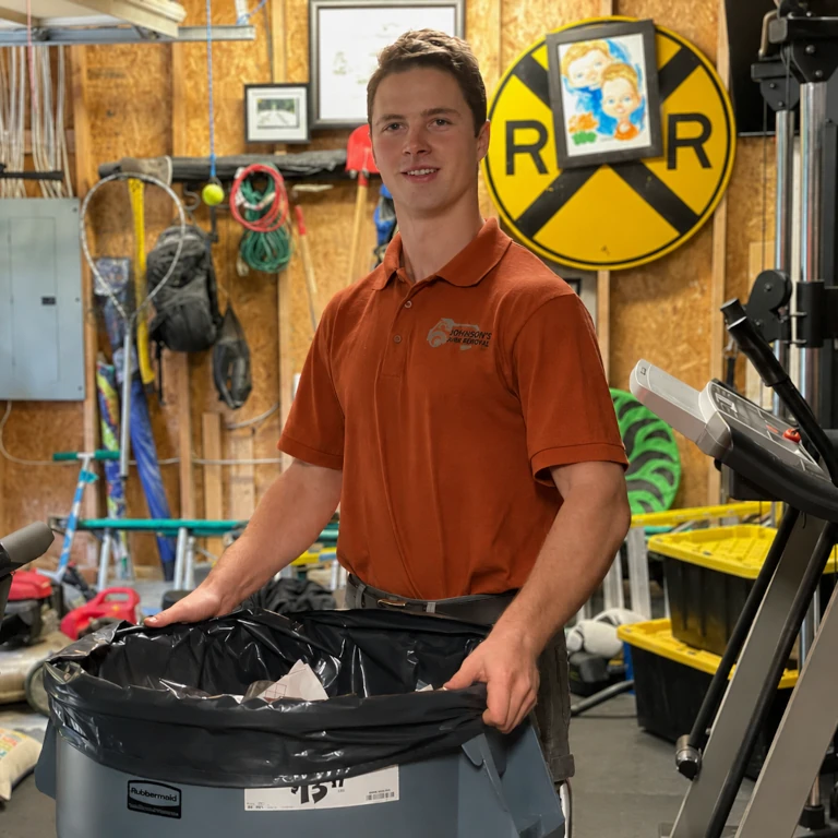 Johnson's Junk Removal' professional holding trash can