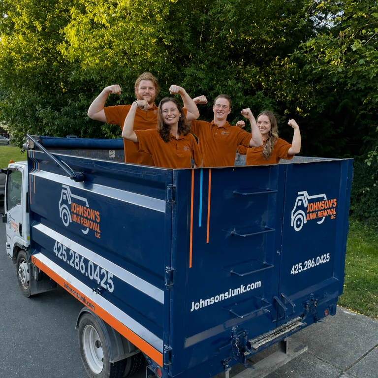 Junk removal professionals posing in the back of the junk removal truck