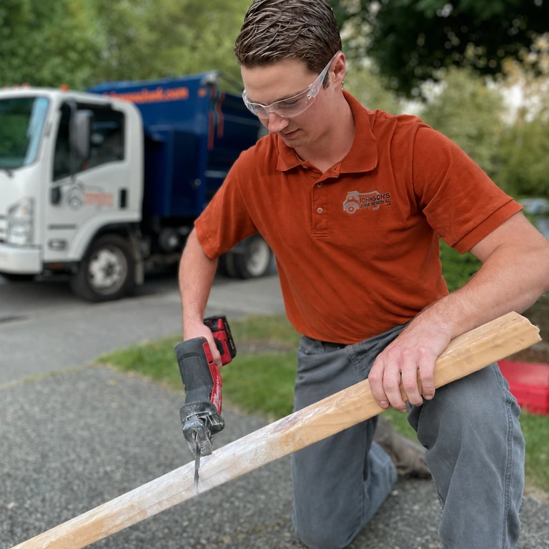 A Johnson's Junk Removal professional performing demolition services for a customer