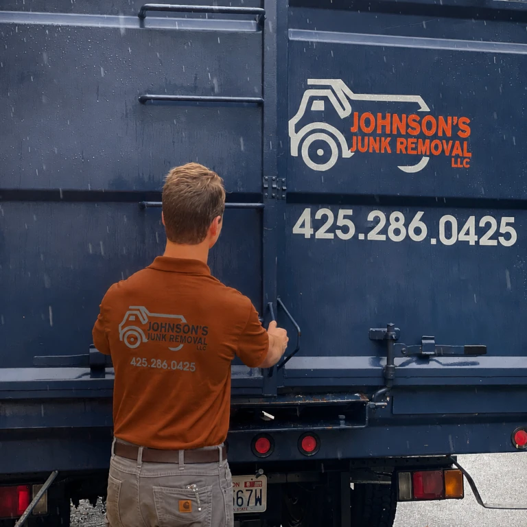 Johnson Junk Removal professional loading junk onto the truck during foreclosure cleanout services